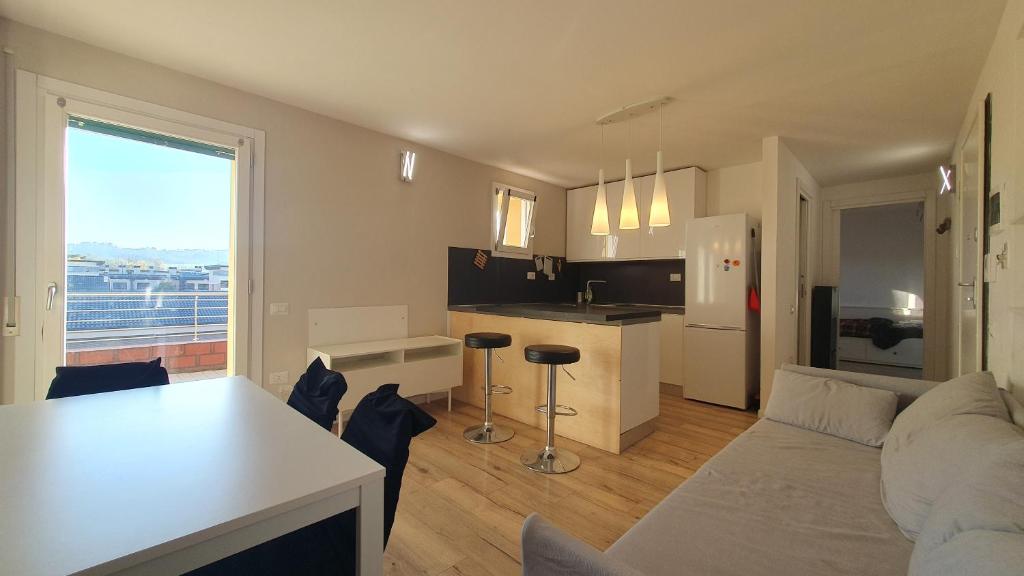 a kitchen and living room with a couch and a table at Ultimo piano con terrazzo e posto auto in Zola Predosa
