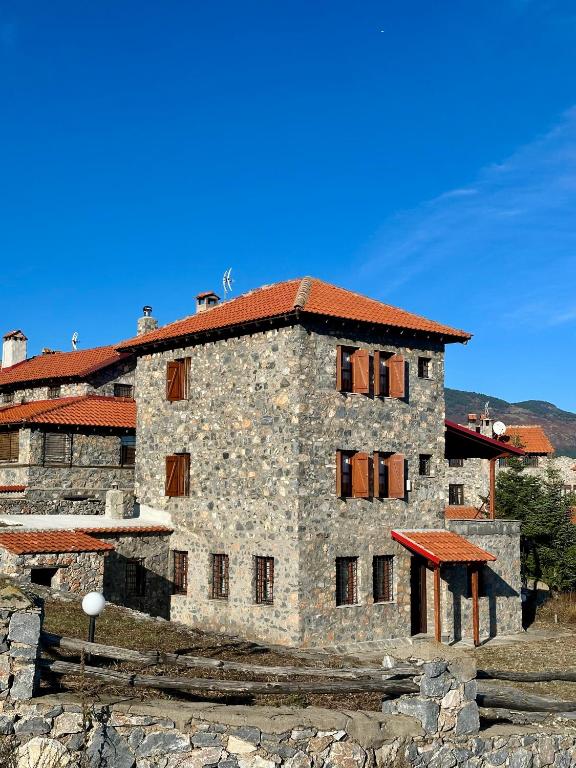 a large stone building with a red roof at ByDoukas Mountain Resort in Palaios Agios Athanasios