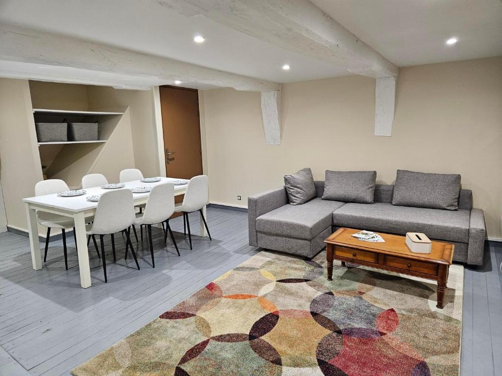 a living room with a couch and a table and chairs at Murmures de la Risle in Pont-Audemer