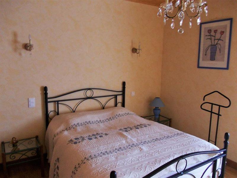 Un dormitorio con una cama y una lámpara de araña en Gîte lumineux, en Antaignagues