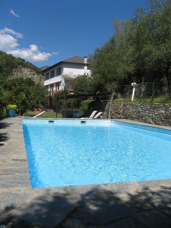 a blue swimming pool in front of a house at Rosa dei Venti in Rapallo