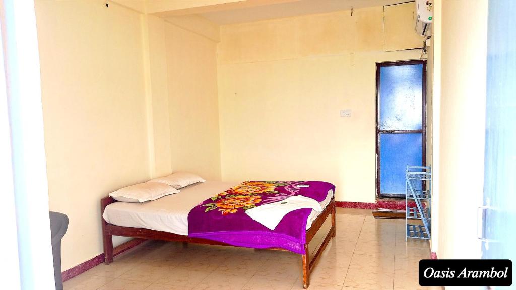 a small bed in a room with a window at Oasis Arambol in Arambol