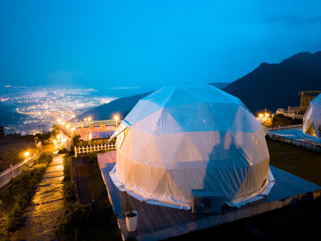 リシケーシュにあるNavira Hills Domes Rishikeshの夜にテントの下に立っている人