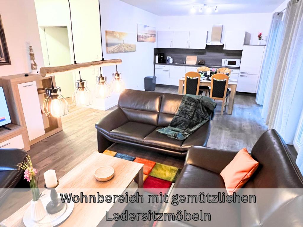 a living room with a leather couch and a table at "Poseidon" Papenburg ebenerdig rollstuhlgerecht Terrasse Einbauküche 84 qm Neubau Free Wifi 2 Schlafzimmer bis 4 Personen in Papenburg