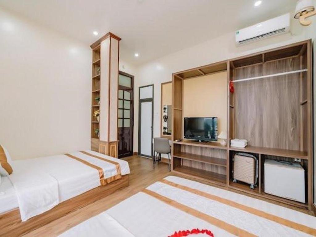 a bedroom with a large bed and a television at Brother Hotel & Travel in Cat Ba