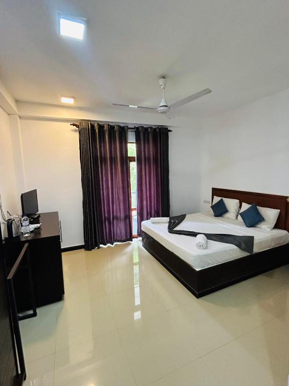 a bedroom with two beds and a television in it at Amelia resort in Udawalayagama