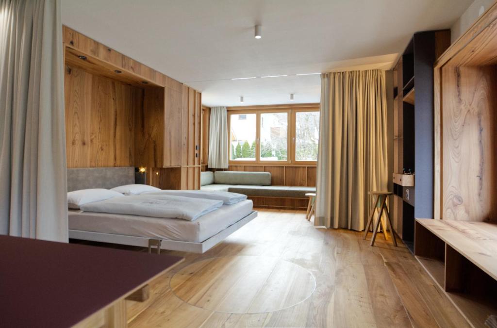 una camera d'albergo con un letto e un divano di Sarti Apparment a San Candido