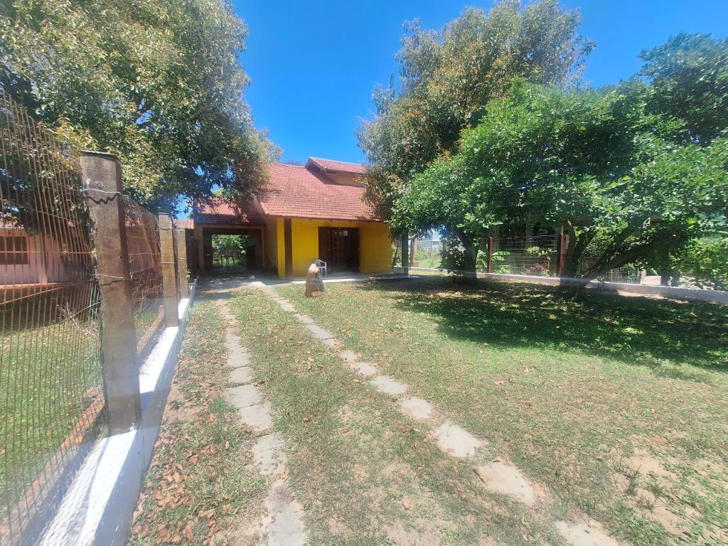 a yard with a fence and a fire hydrant at Casa mami 800 mts do mar in Capão da Canoa