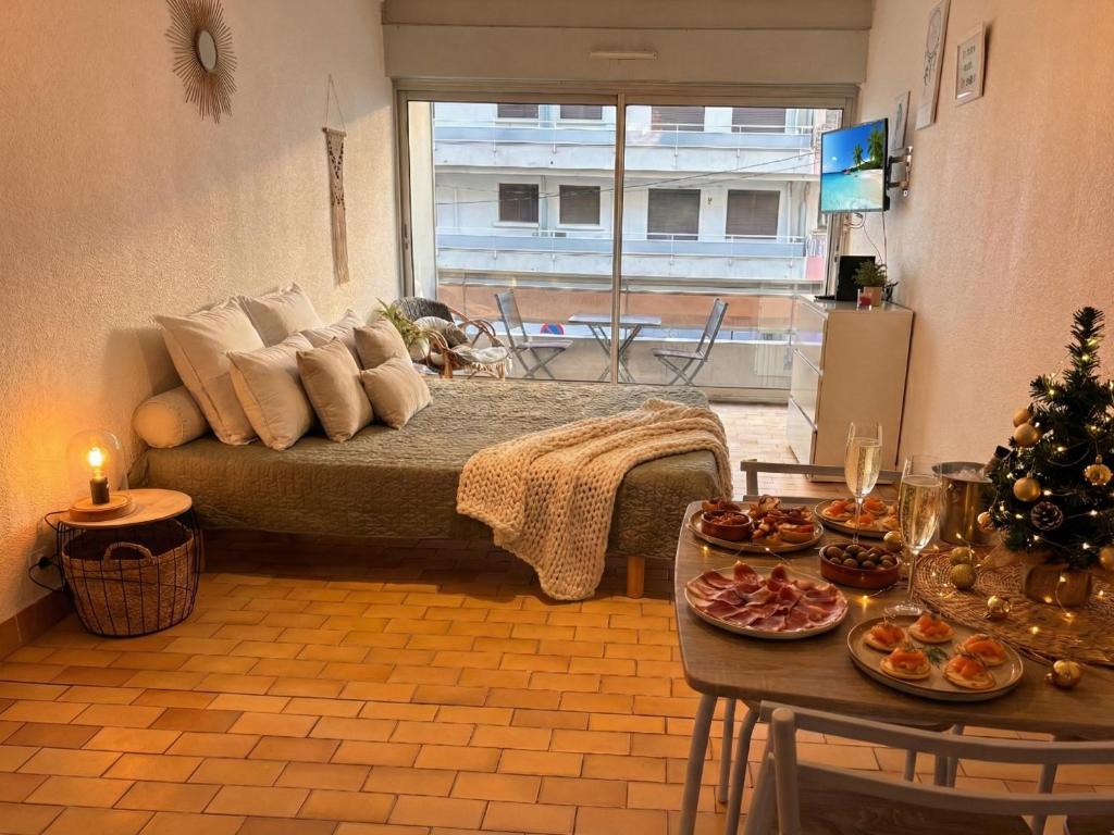 a room with a bed and a table with food on it at Studio à 100m de la plage avec balcon - 66 in Canet-en-Roussillon