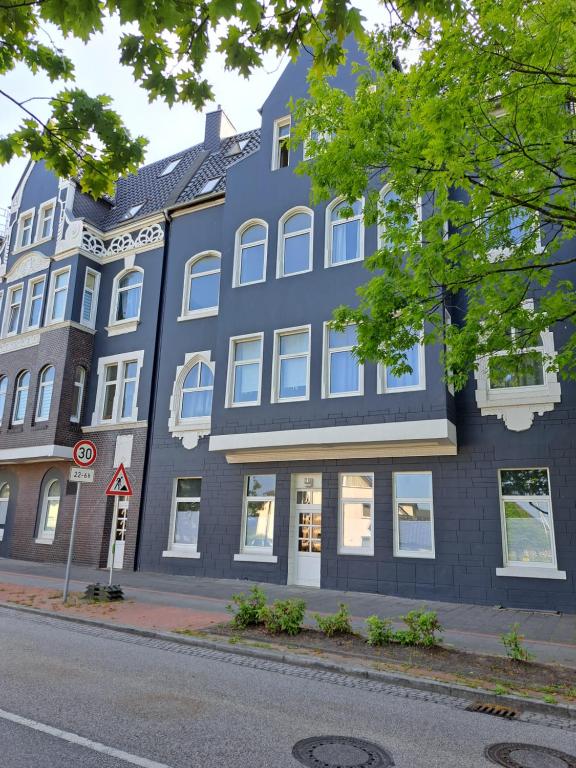 a large blue building on the corner of a street at Midtown Geeste Appartement - Free Parking & WiFi in Bremerhaven