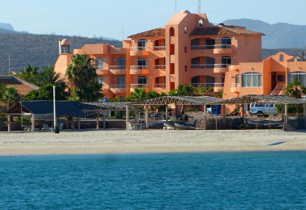 a building on the beach next to the water at Club Cantamar Beach Hotel & Marina in La Paz