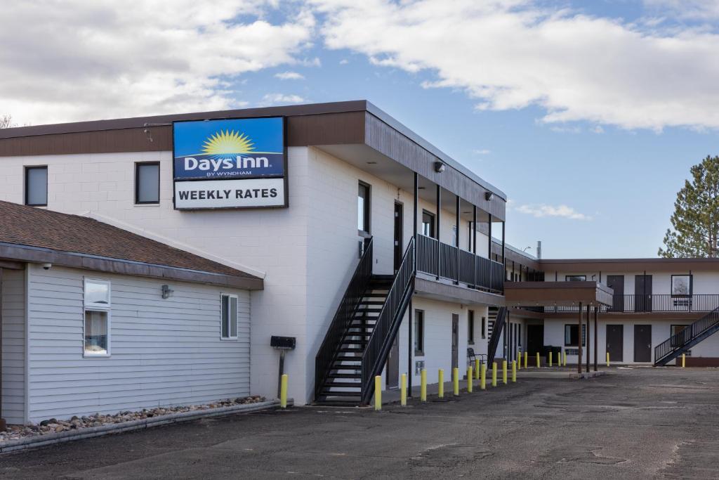 a building with a sign that reads dysin weekly rates at Days Inn by Wyndham Wheatland in Wheatland