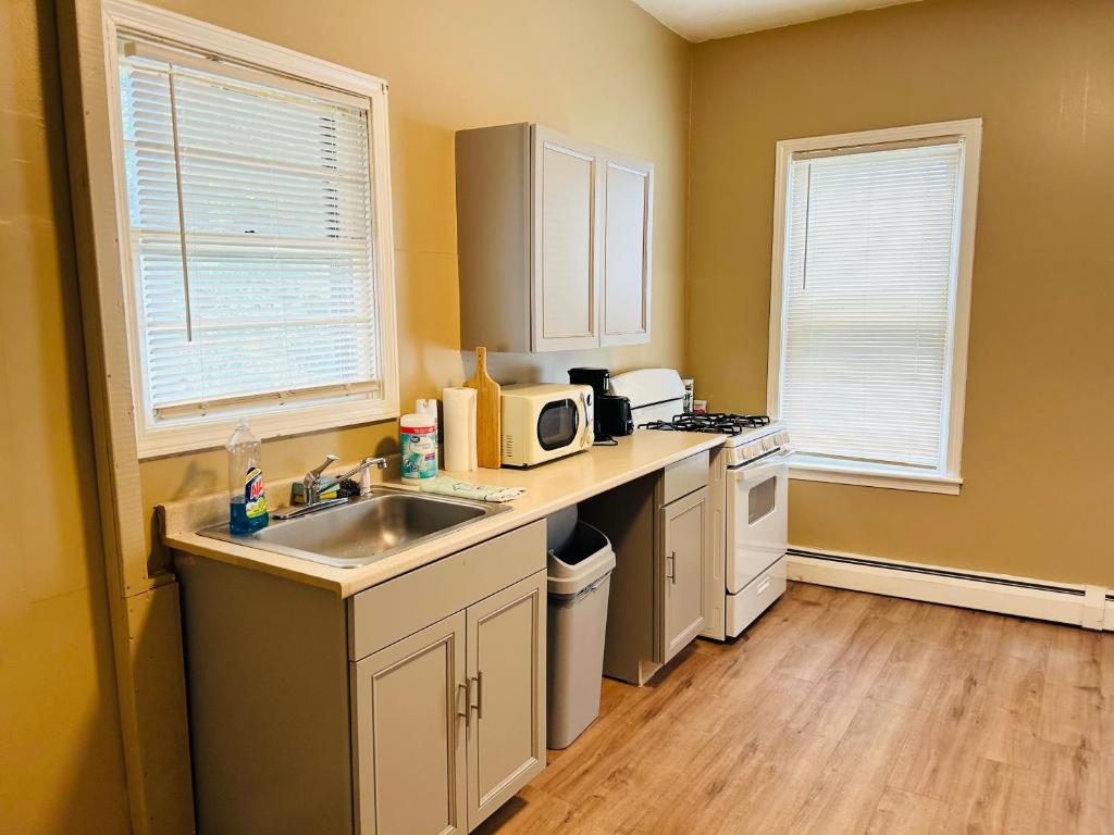 a small kitchen with a sink and a microwave at Apartments near Whole Foods, Brown University, Miriam, Downtown in Providence
