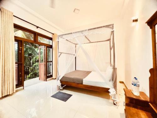 a bedroom with a bed with a mosquito net at Samaro Resort in Mirissa