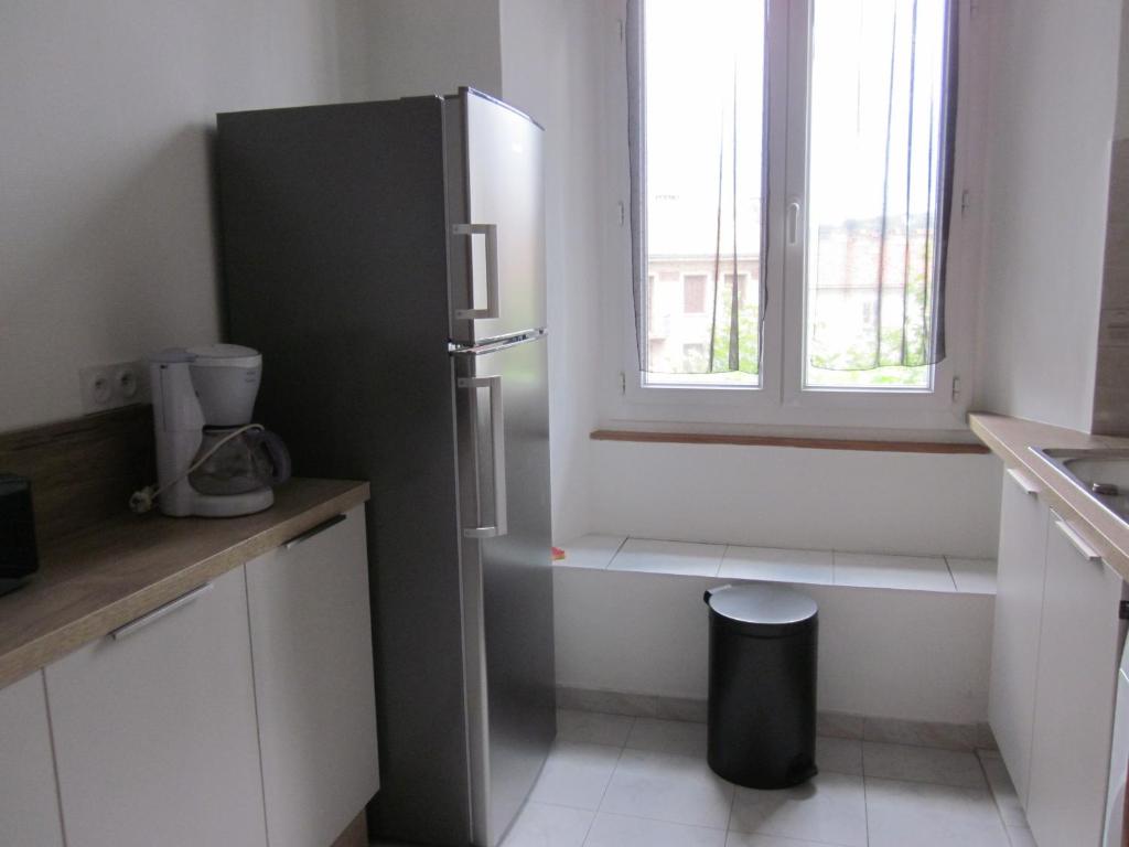 a kitchen with a refrigerator and a window at Douillet F1 Place Paoli in Corte