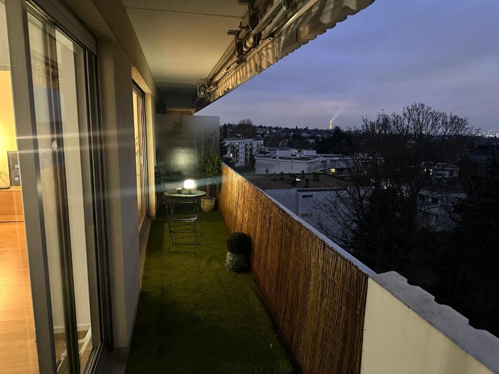 un balcon avec vue sur une ville la nuit dans l'établissement Appartement vue sur Tour Eiffel, à Garches