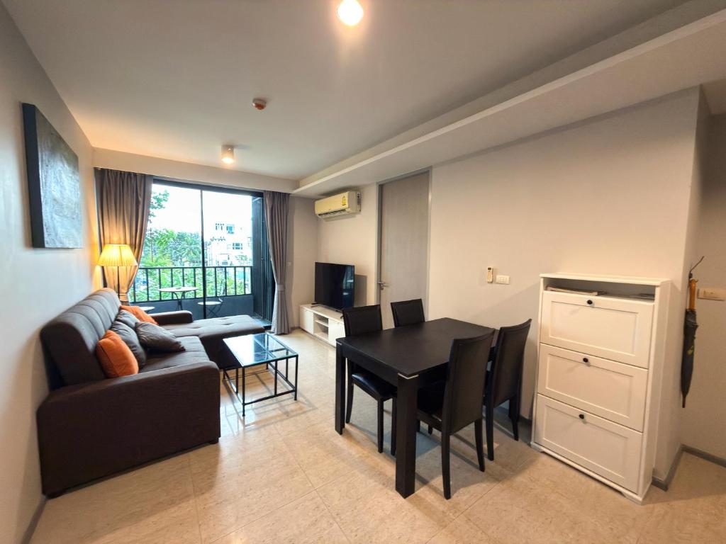 ein Wohnzimmer mit einem Sofa und einem Esstisch in der Unterkunft 6th Avenue 2 bedroom in Surin Beach