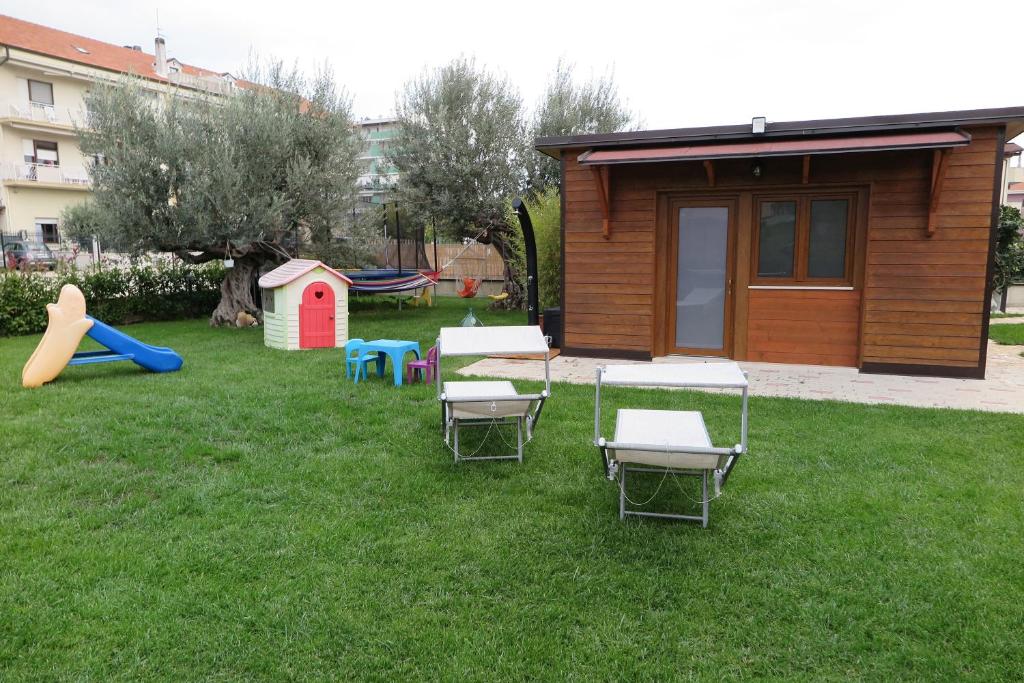 een tuin met stoelen en een speeltuin met een huis bij Dependance Con Giardino A Pescara in Pescara