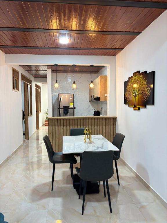 Apartamento Jardines Guaduas Cundinamarca في غوادواس: غرفة طعام مع طاولة بيضاء وكراسي