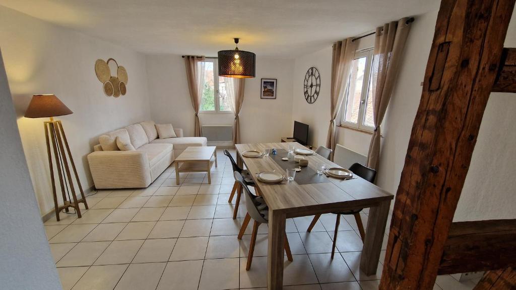 a living room with a table and a couch at La vita è bella in Sélestat