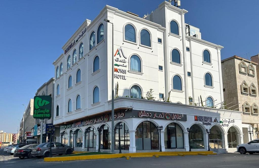 ein großes weißes Gebäude an der Ecke einer Straße in der Unterkunft فندق منسي Monsi Hotel in Ta'if