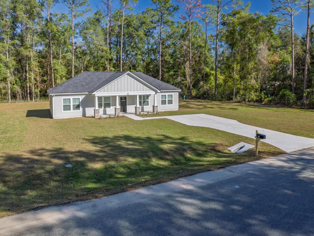 una casa bianca con un vialetto di fronte a un cortile di Seabreeze Pines a Crawfordville
