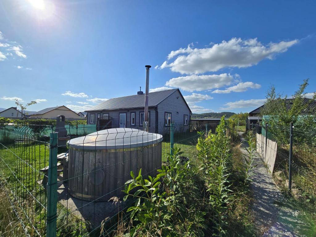 a fence in front of a house with a building at Domki Śnieżka in Wojcieszyce