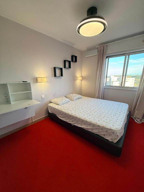 1 dormitorio con 1 cama y alfombra roja en DhaliHOUSE, en Mealhada