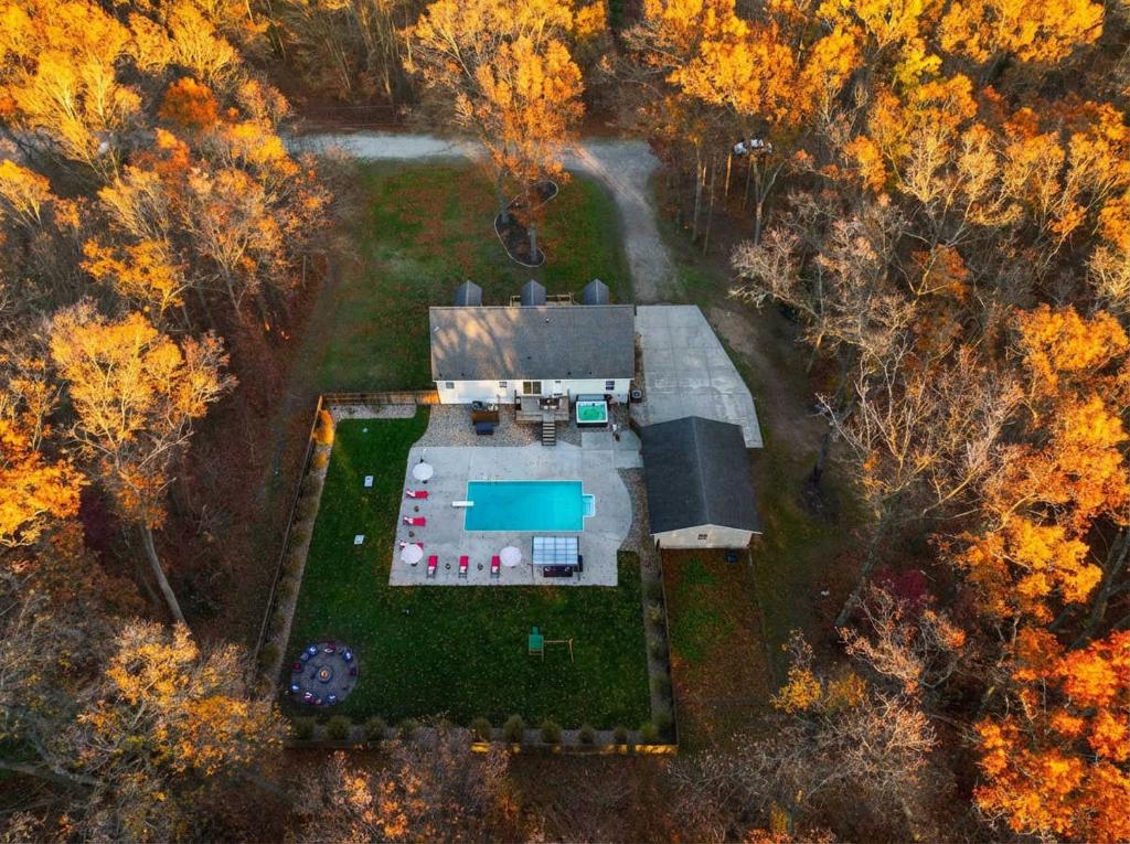 Pine & Paddle Getaway Game Room Hot Tub Pool في مسكيغون: منظر جوي لمنزل مع حديقة