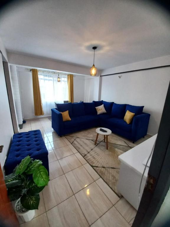 a living room with a blue couch and a table at Delightfulstaycation in Nanyuki