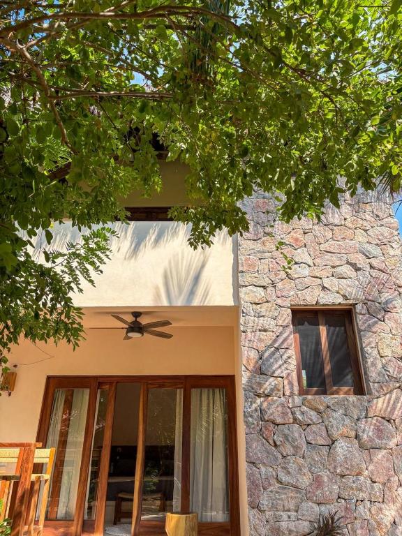 a stone building with a ceiling fan in front of it at Villas Indigo Troncones in Troncones
