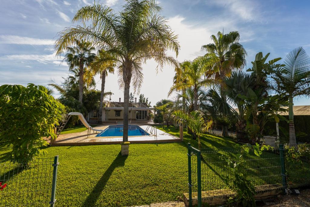 a yard with a swimming pool and palm trees at Casa Rural EL CAMPICO in Puerto de Mazarrón