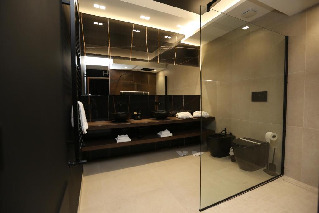 a bathroom with a glass shower and a toilet at Il Moro Luxury Rooms in Siracusa