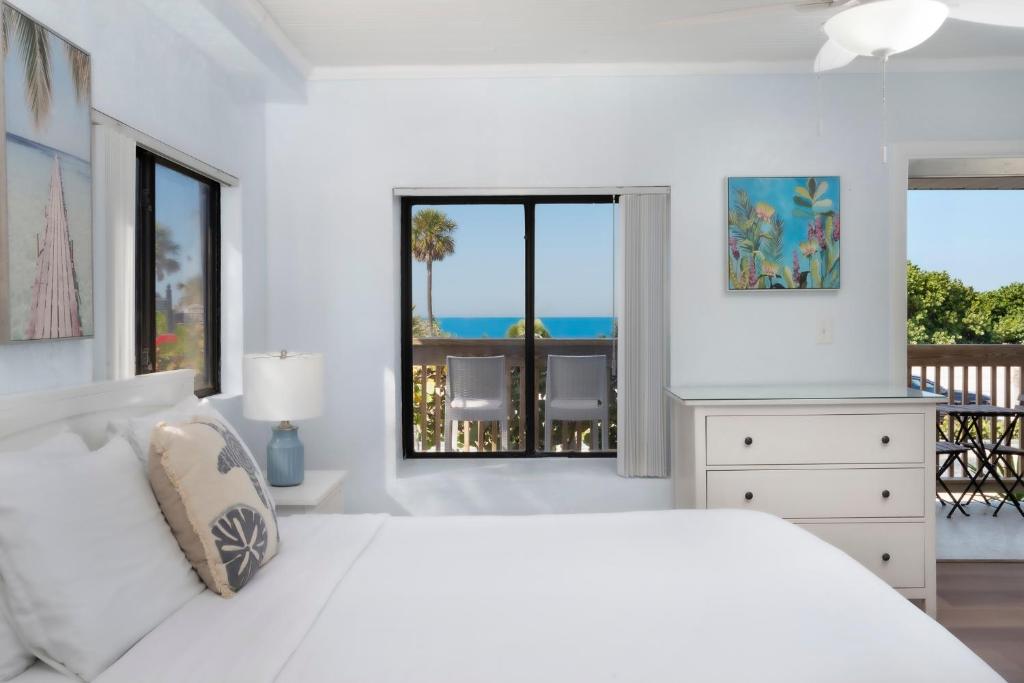 ein weißes Schlafzimmer mit Bett und Meerblick in der Unterkunft Sabal Palms Inn in St Pete Beach