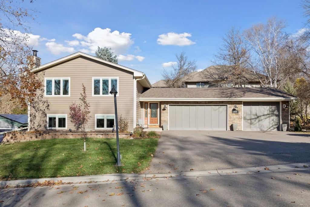 Modern Upper Unit, Hot Tub, Medicine Lake في مينيابوليس: منزل به كراج ابيض وممر