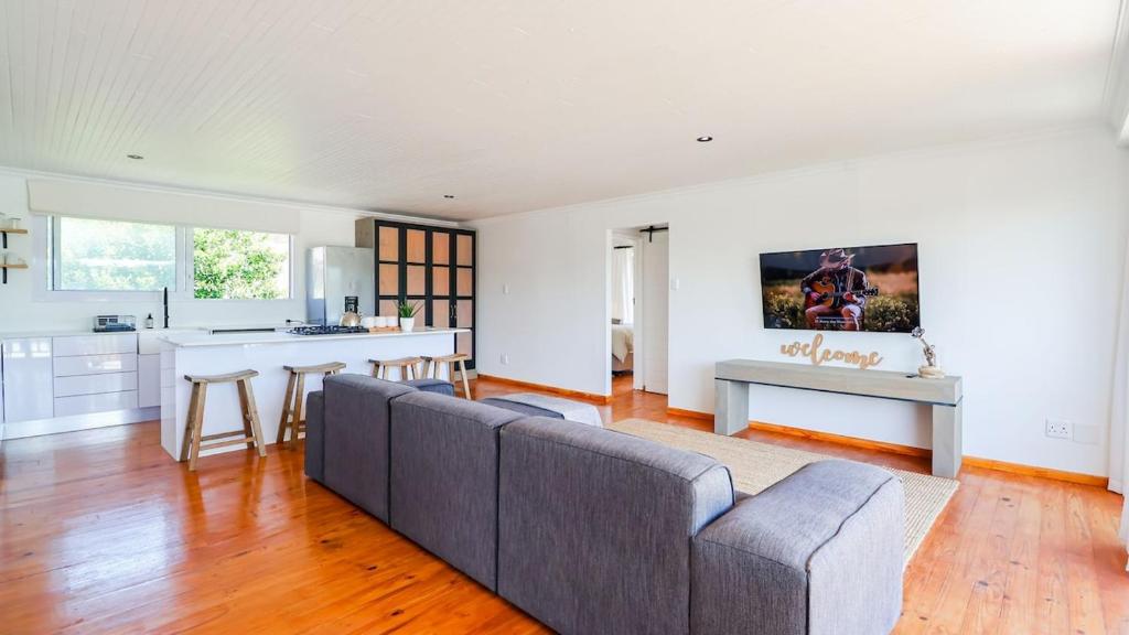 a living room with a couch and a kitchen at Hideaway in Herolds Bay