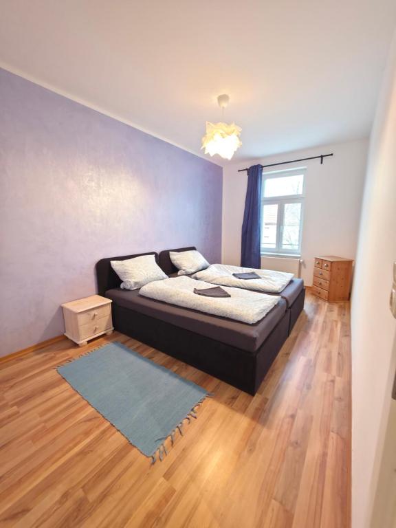 a bedroom with a bed and a wooden floor at Ruhiges Apartment Leipziger Neuseenland, direkte S-Bahn Anbindung Leipzig sowie Messe in Neukieritzsch