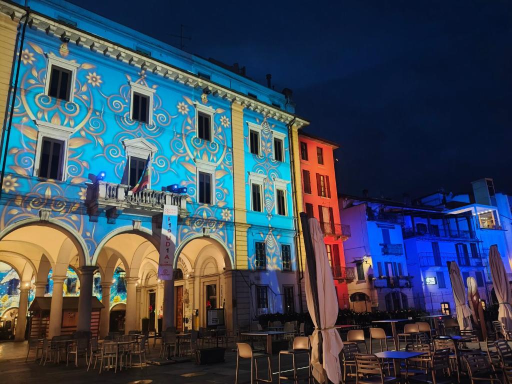 a building with chairs and tables in front of it at Residenza Gattoni in Omegna