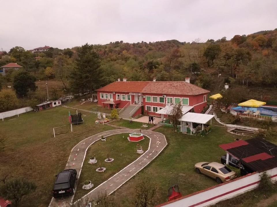 a large red house with cars parked in front of it at Къща за гости сБолярци 