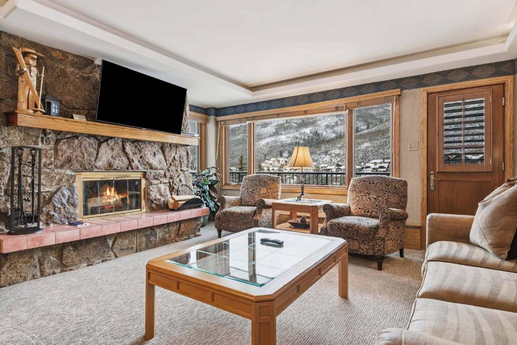 a living room with a fireplace and a tv at Lodge Tower 594 One Bedroom Residence in Vail