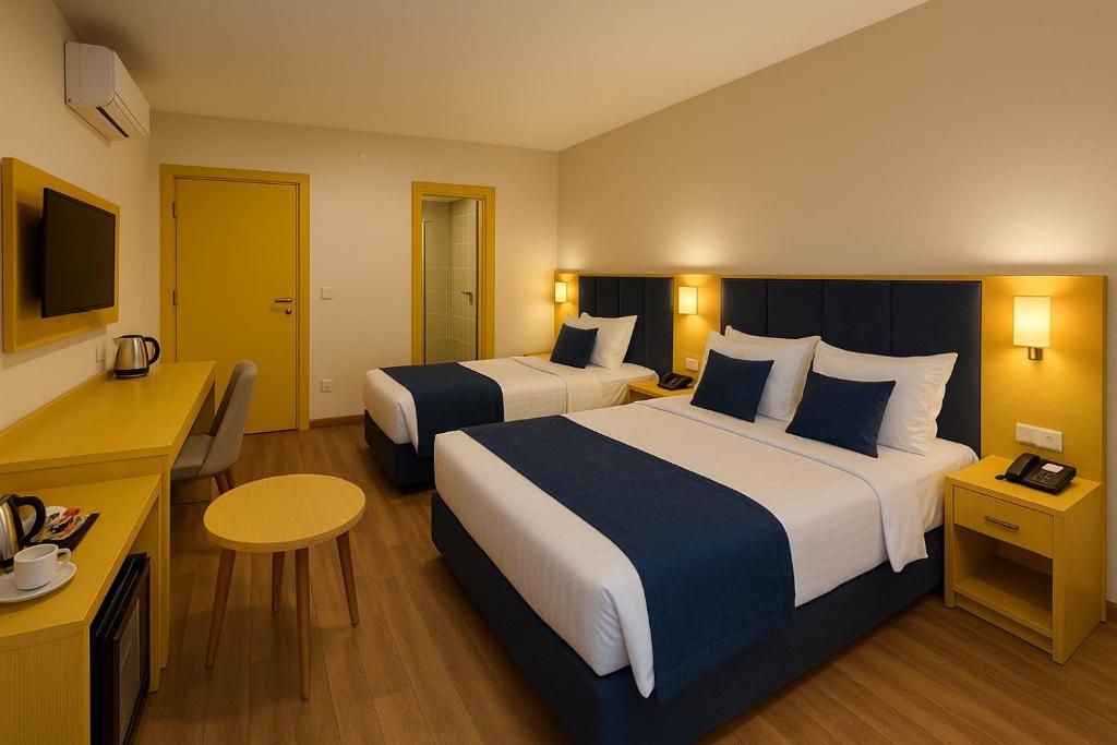 巴库Khatai Deluxe Hotel的一间酒店房间，里面有两张床和一张桌子。