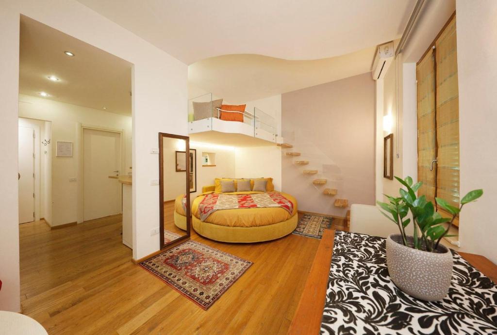 a bedroom with a bed and a staircase in a room at Siena UpTown - Sabrina's Cozy Apartment in Siena