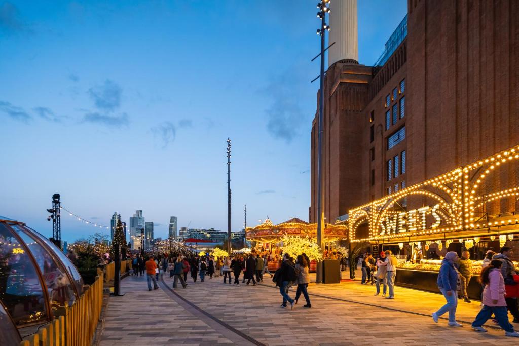 فندق وسبا بيستانا تشيلسي بريدج في لندن: مجموعة من الأشخاص يسيرون في شارع مزين بأضواء عيد الميلاد