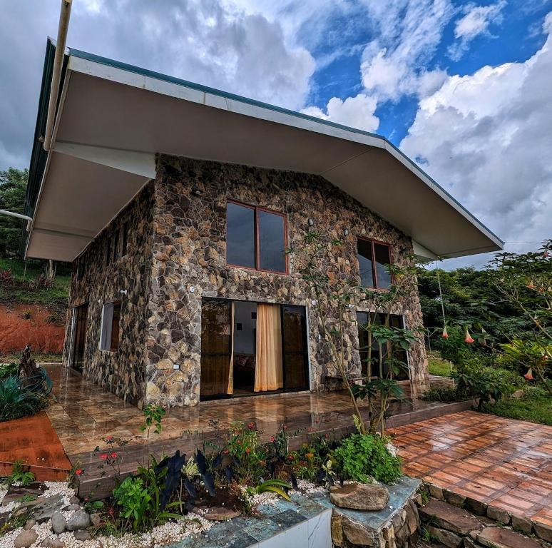 a stone house with a large roof at Villa Piedra Viva in Tilarán