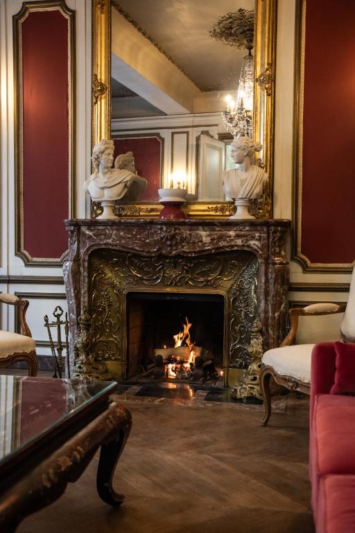 a living room with a fireplace with a fire in it at Maison la Louise in Ligny-en-Barrois
