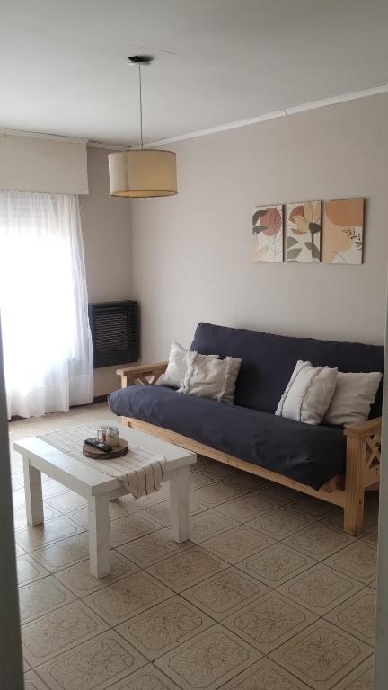 a living room with a blue couch and a table at Aguaribay in Chivilcoy