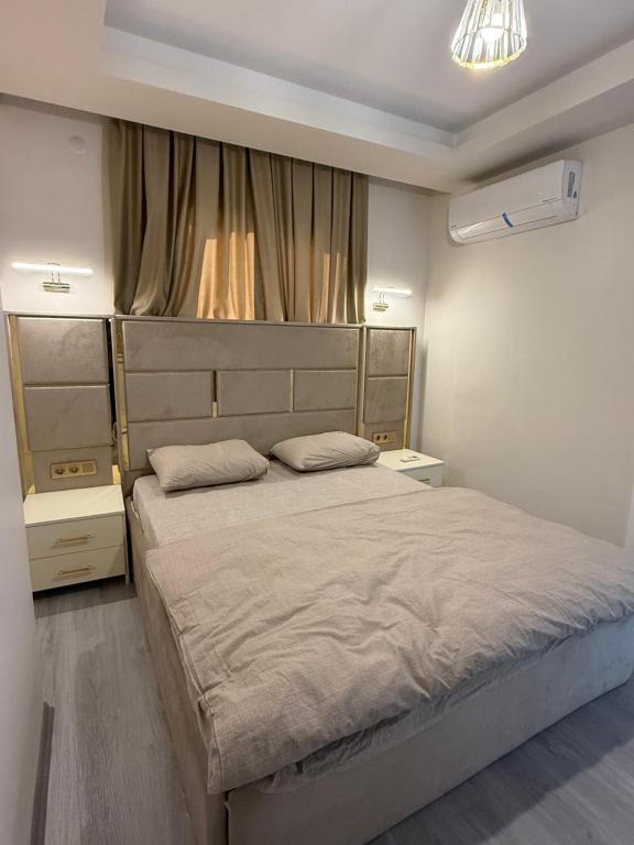 a bedroom with a large bed and two night stands at Aljari otel in Mezitli