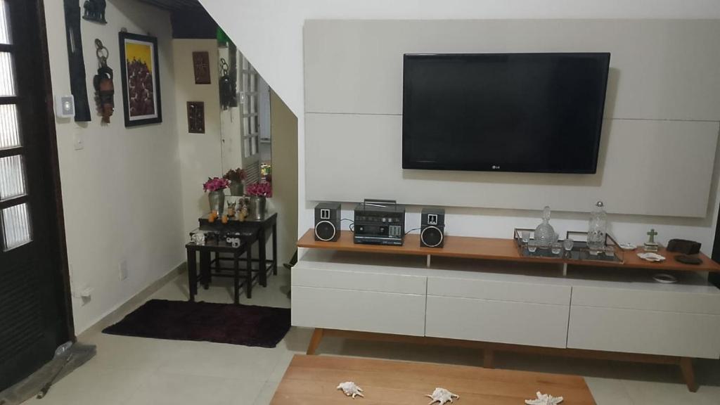 a living room with a flat screen tv on a wall at Casa grande e aconchegante, muito central, aluguel de quartos in Natal