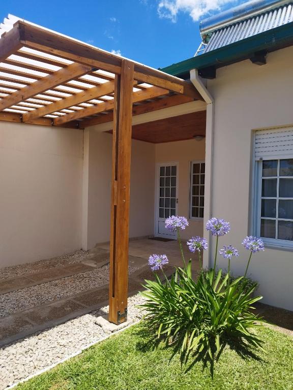 a wooden pergola on the side of a house at Refugio del viajero in Chajarí