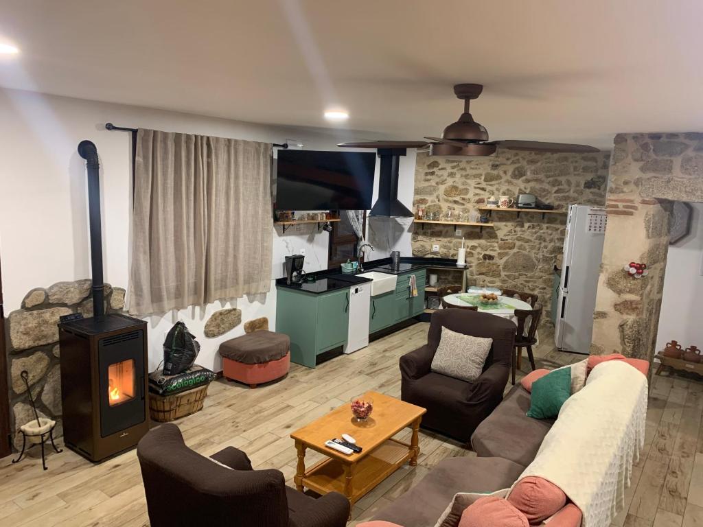 CASA RURAL PUERTO-Ideal para disfrutar en familia في Casas del Monte: غرفة معيشة مع أريكة وموقد